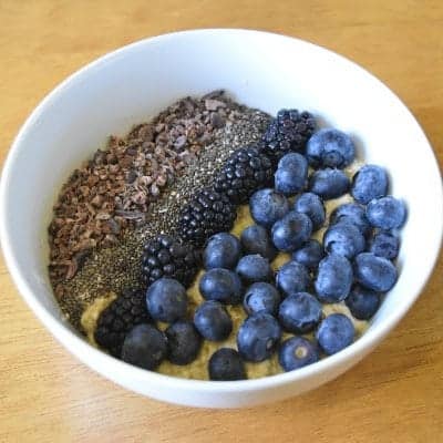 Fresh blueberries with chia seeds and ground flaxseed in a white bowl.