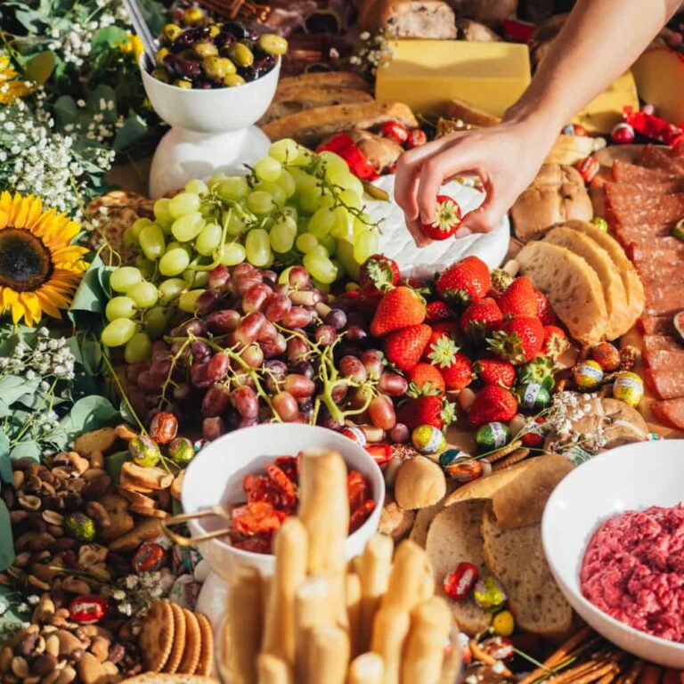 Fresh fruit and cheese platter with strawberries, grapes, and assorted snacks for a pleasurable food experience.