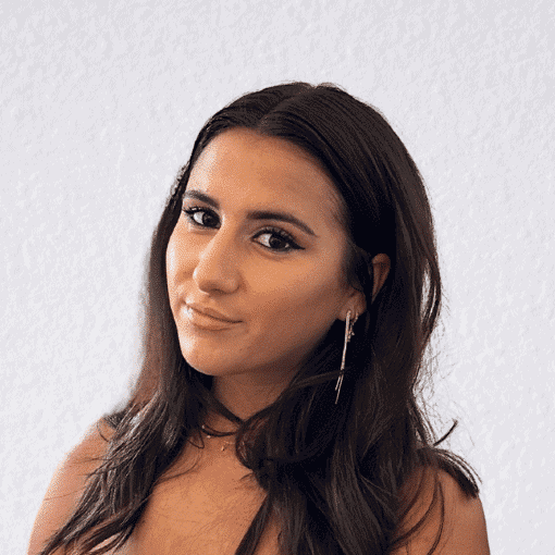 Confident woman with dark hair and earrings, looking at camera.