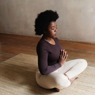 Woman practicing mindfulness meditation in seated prayer pose, representing the CPD-accredited Meditation, Mindfulness & Breathwork for Coaches self-study course.