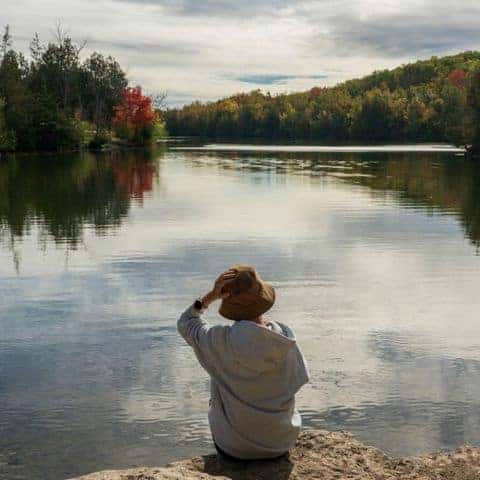 Serene lakeside view with a person reflecting on life and nature.